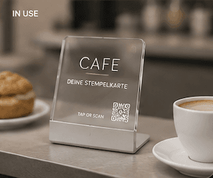 PLINQ Touchpoint im Einsatz auf einem Café-Tresen neben Kaffee und Gebäck
